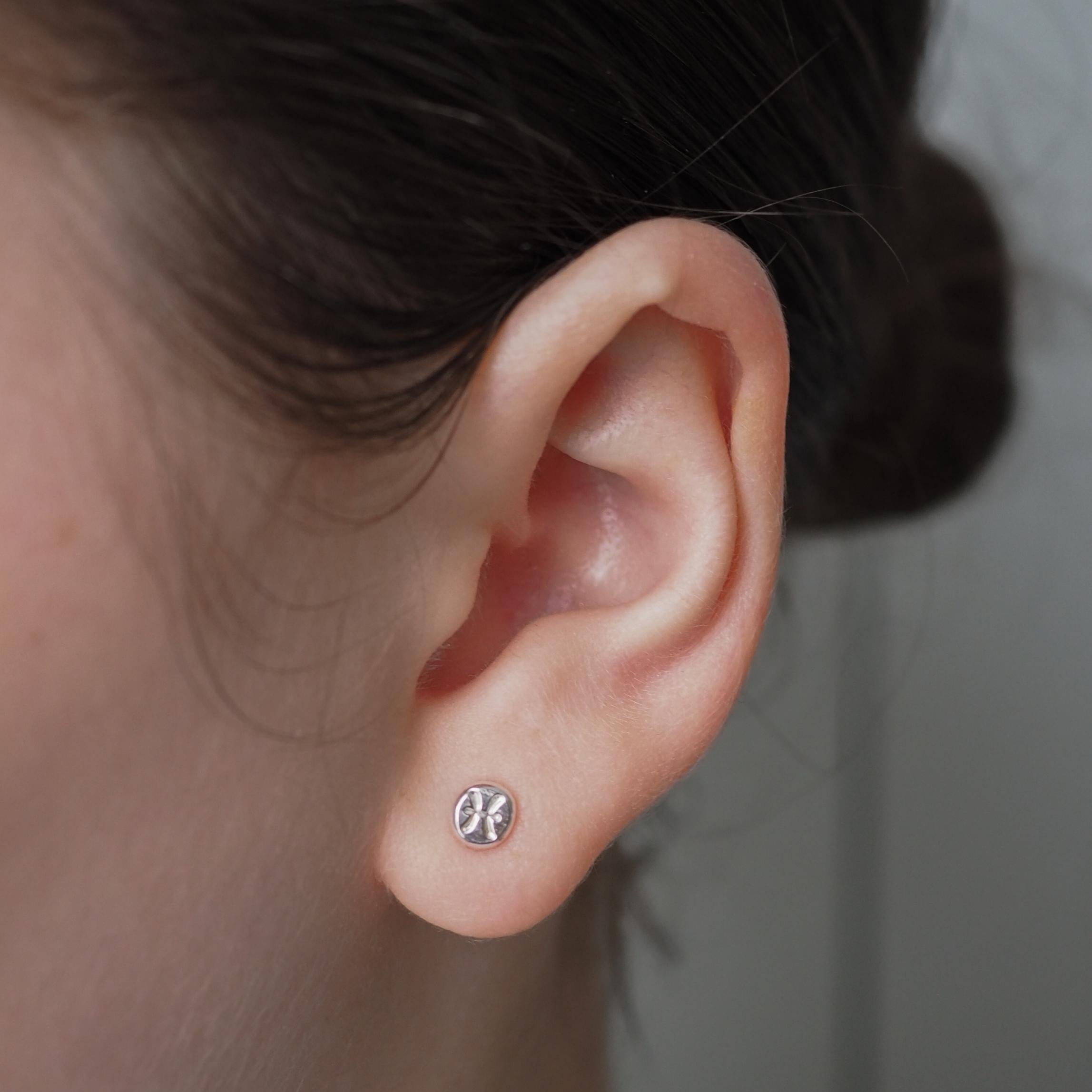 Person wearing a single Organic Zodiac Stud Earring, displaying subtle, personalised zodiac design