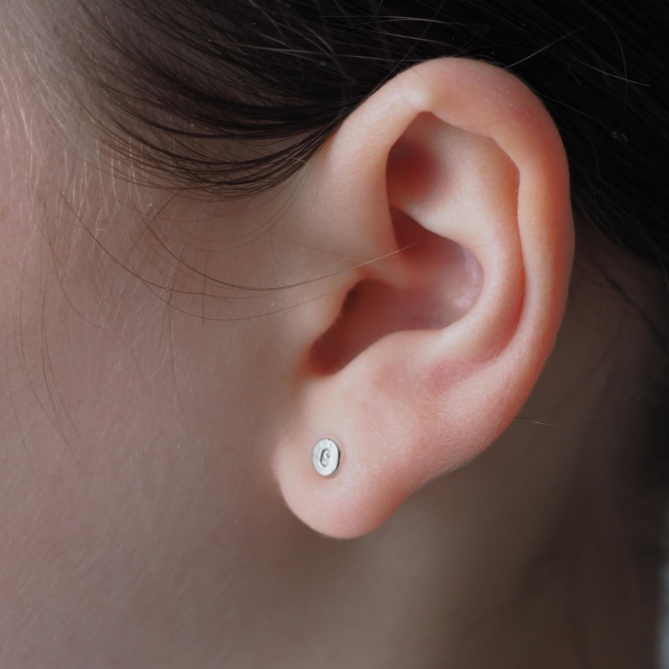 Person wearing a single Organic Initial Stud Earring, displaying a dainty, personalised design