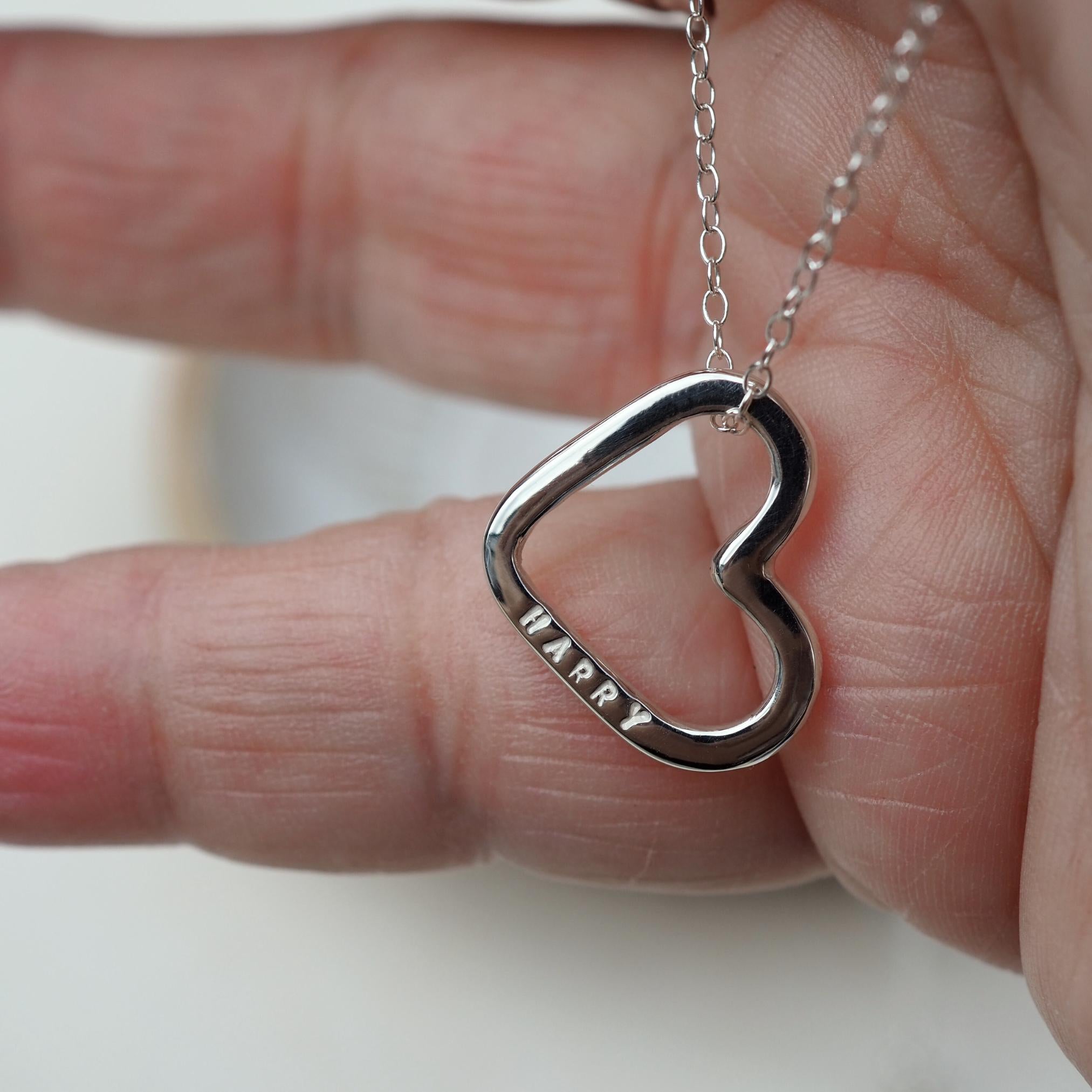 Close up of an open heart necklace in sterling silver