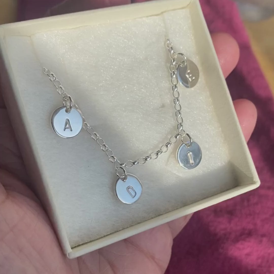 Personalised silver bracelet with hand-stamped initials in a gift box.