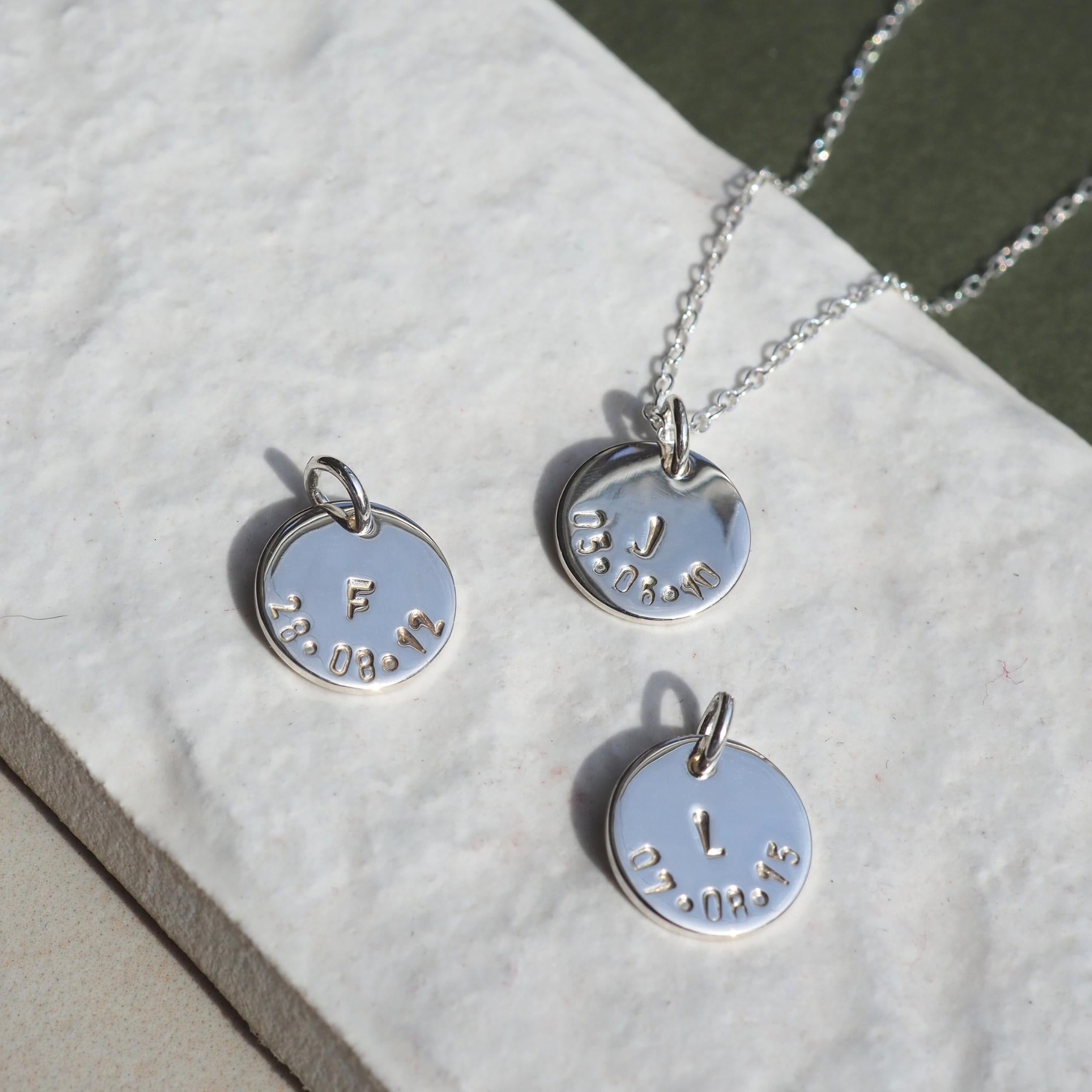 Hand-stamped charms with initial and date in sterling silver