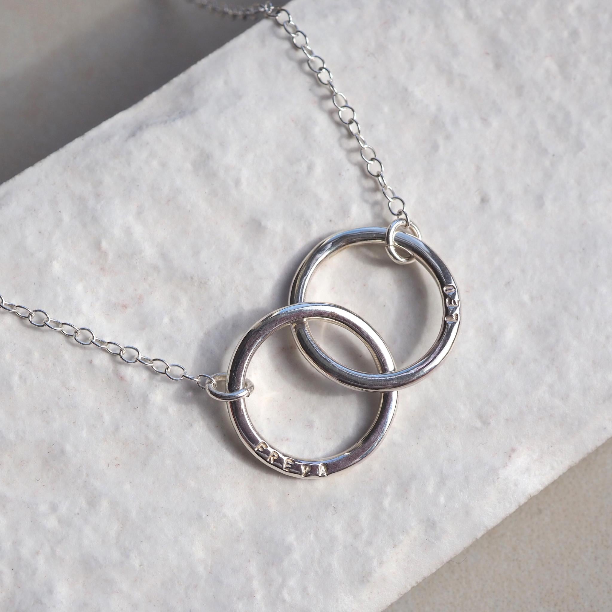 Double halo necklace in sterling silver, hand-stamped with names