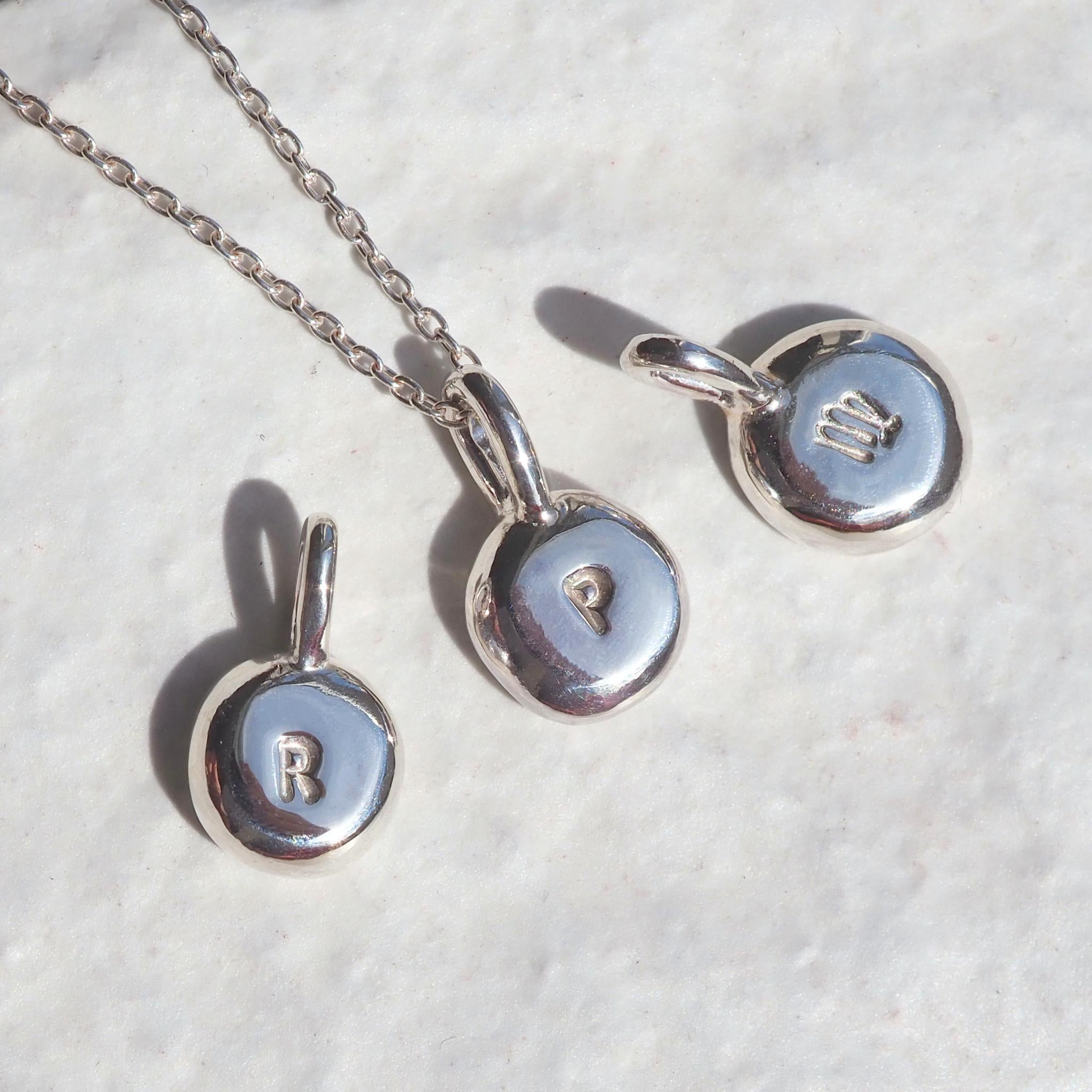 Custom molten pebble necklace in silver, personalised with initials or zodiac signs