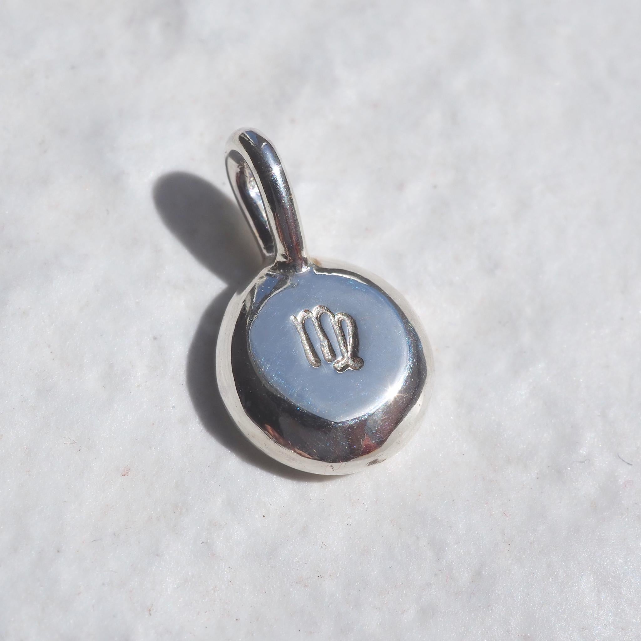 Molten pebble necklace in silver, personalised with a hand-stamped zodiac symbol